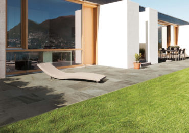 Outdoor tile flooring surrounding a luxury home with a sleek lounge and dining area